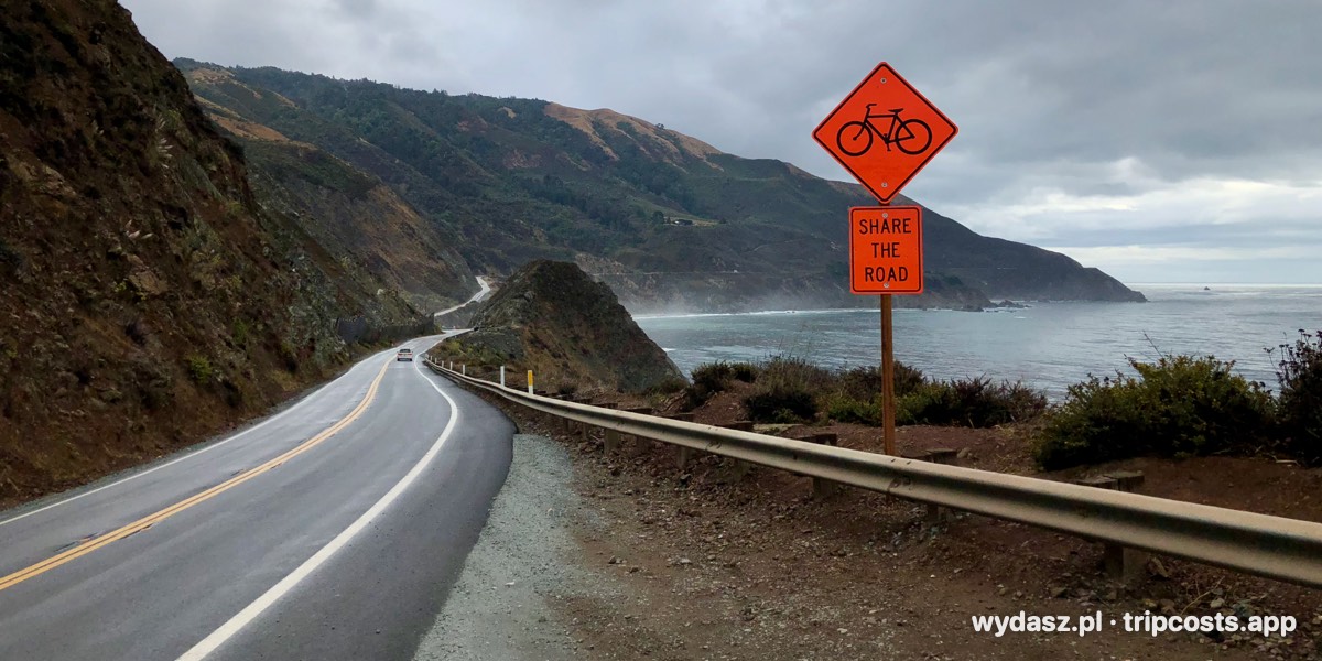 Kręta Highway 1 nad Pacyfikiem w Big Sur, pod chmurami, ze znakiem ostrzegającym przed rowerzystami