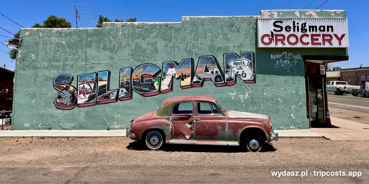 Stary samochód przed muralem z napisem Seligman na Route 66 w Arizonie